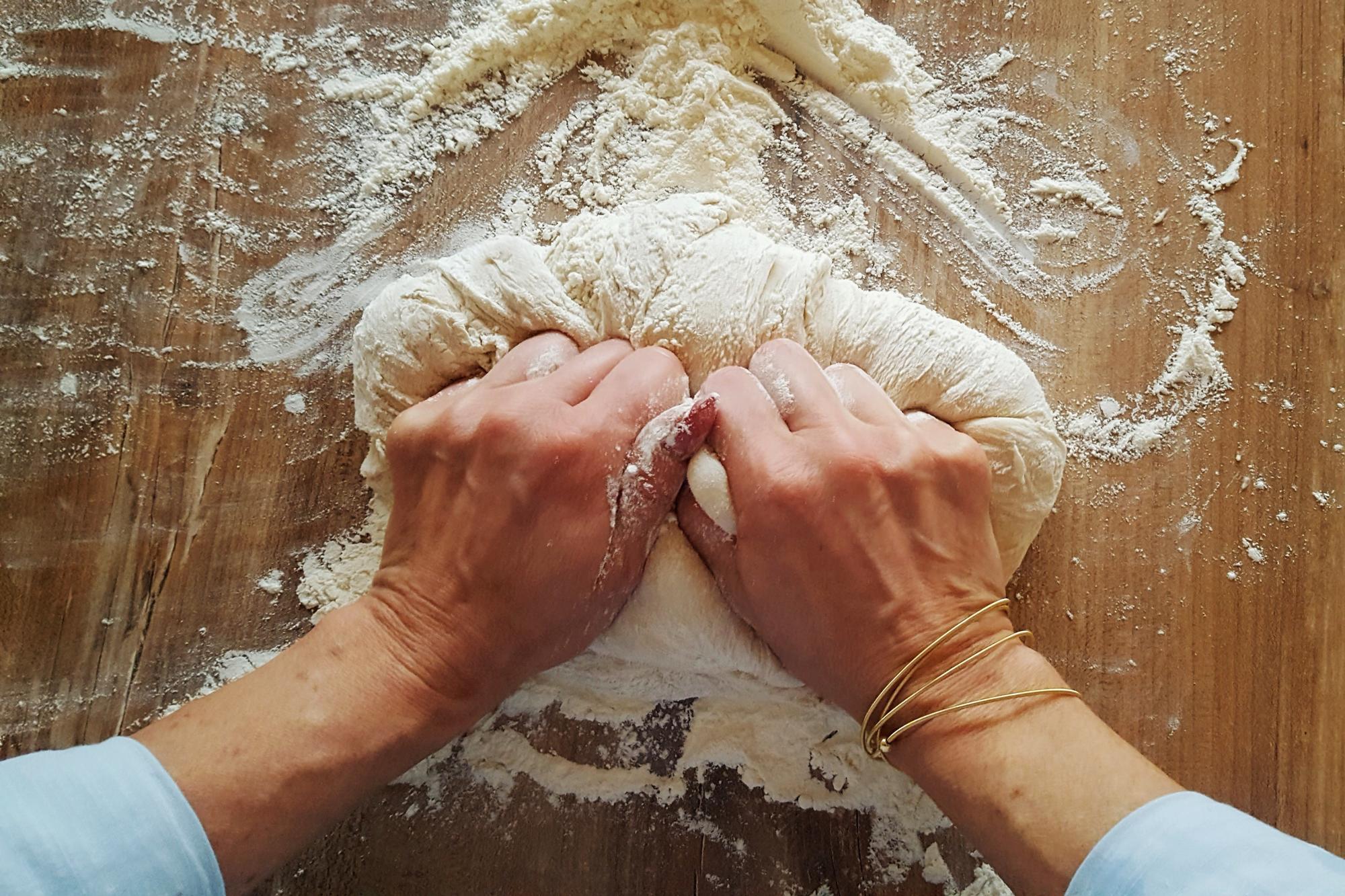 Dettaglio di mani che impastano con precisione